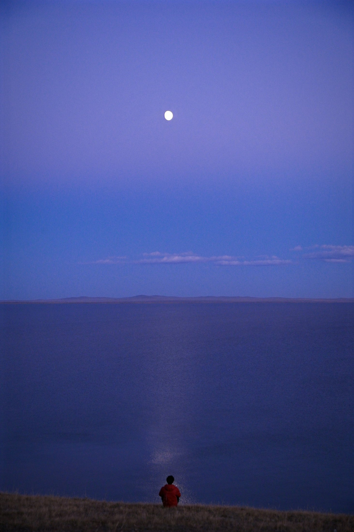 Sitting by a lake under the moon